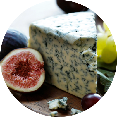 Blue cheese wedge with figs and grapes on a wooden board