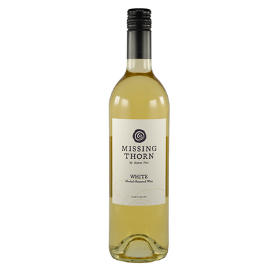 A bottle of non-alcoholic white wine labeled 'Missing Thorn' with a clear, yellow-tinted liquid visible through the bottle.