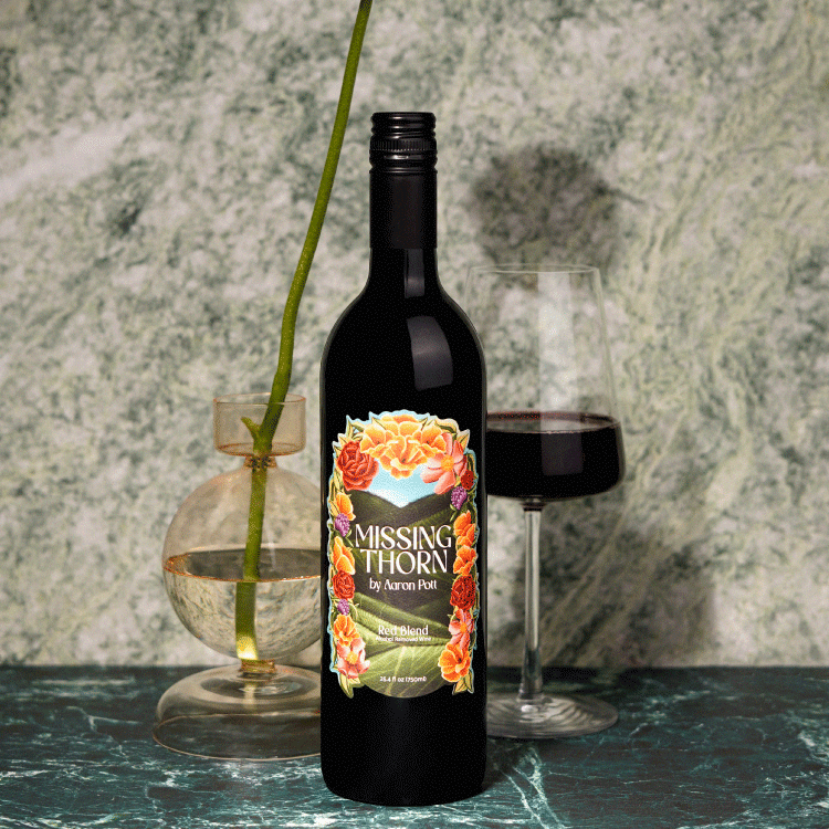 Missing Thorn Red Bordeaux wine bottle with glass and a vase in the background