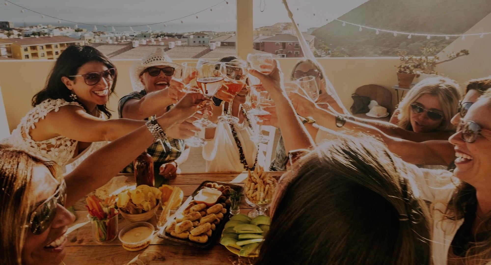 Group of people celebrating with drinks at a rooftop party.