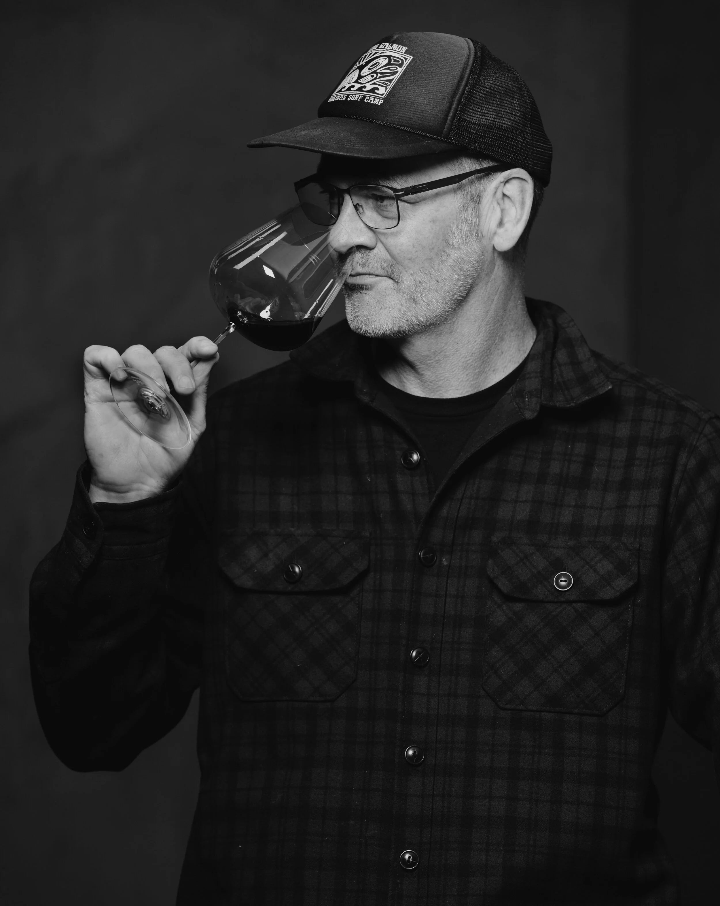 Man tasting wine with a dark background